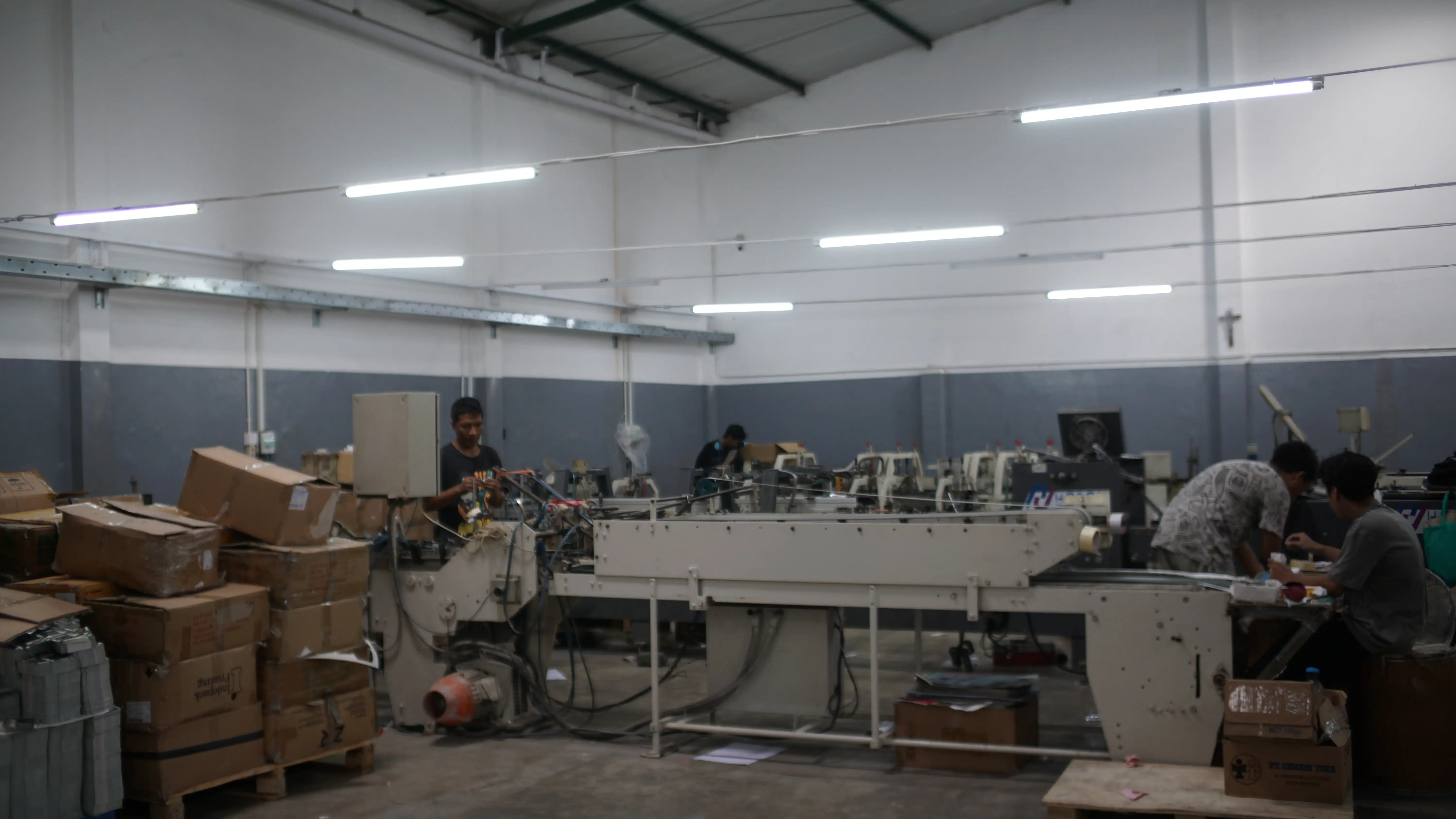 Tim profesional sedang berdiskusi di ruang meeting modern dengan laptop dan whiteboard